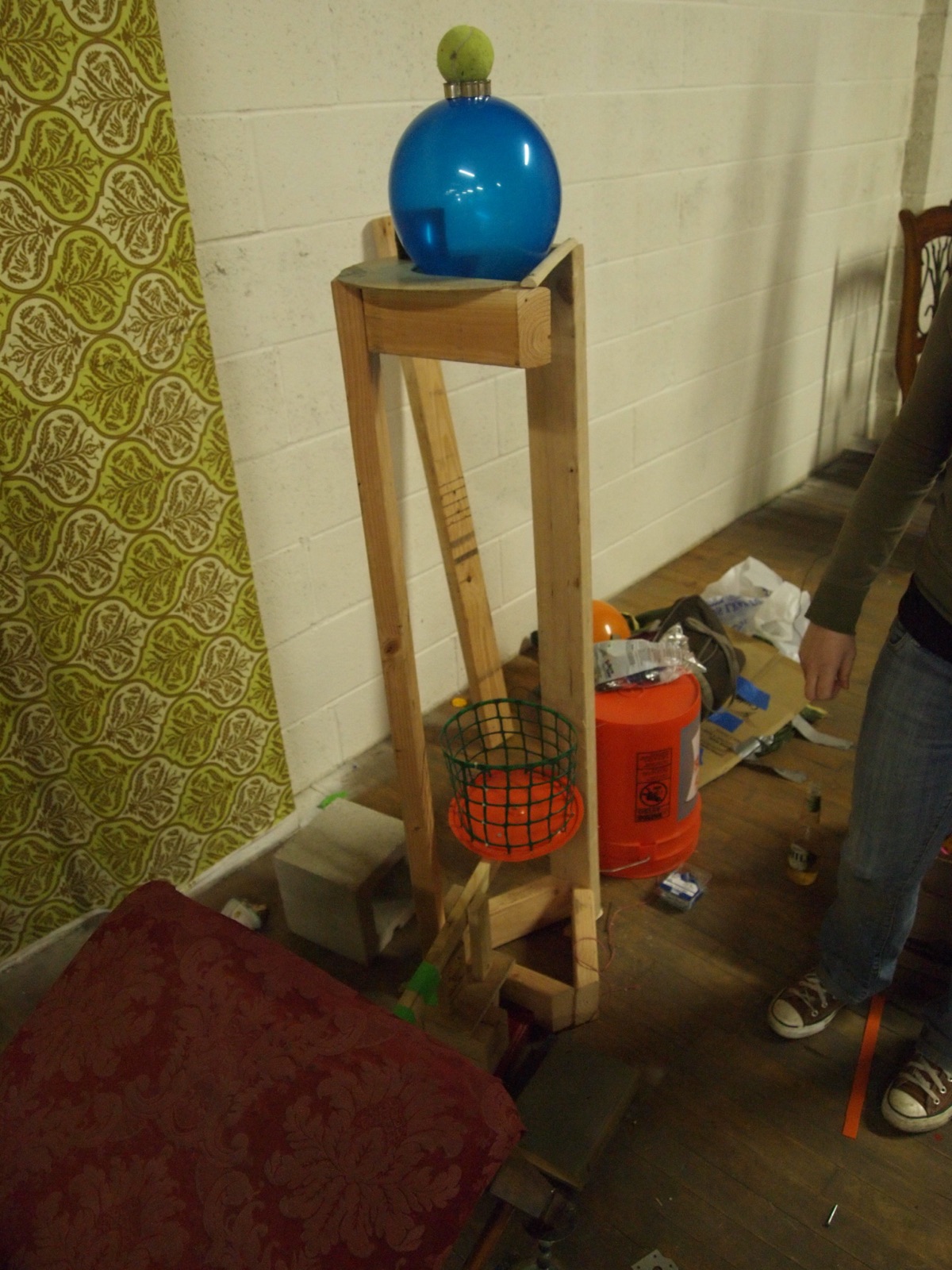 A tall wooden stand with a blue ball on top in the warehouse