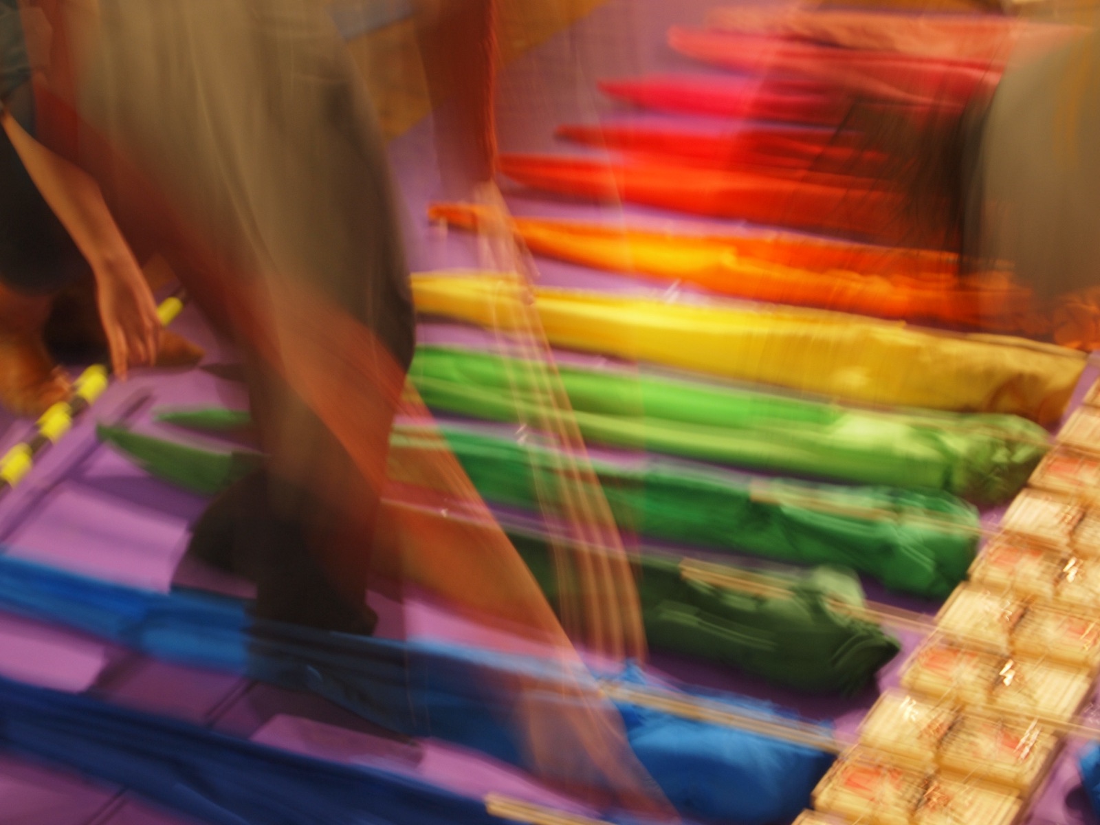 Rainbow fabric and a line of mousetraps, blurred by motion