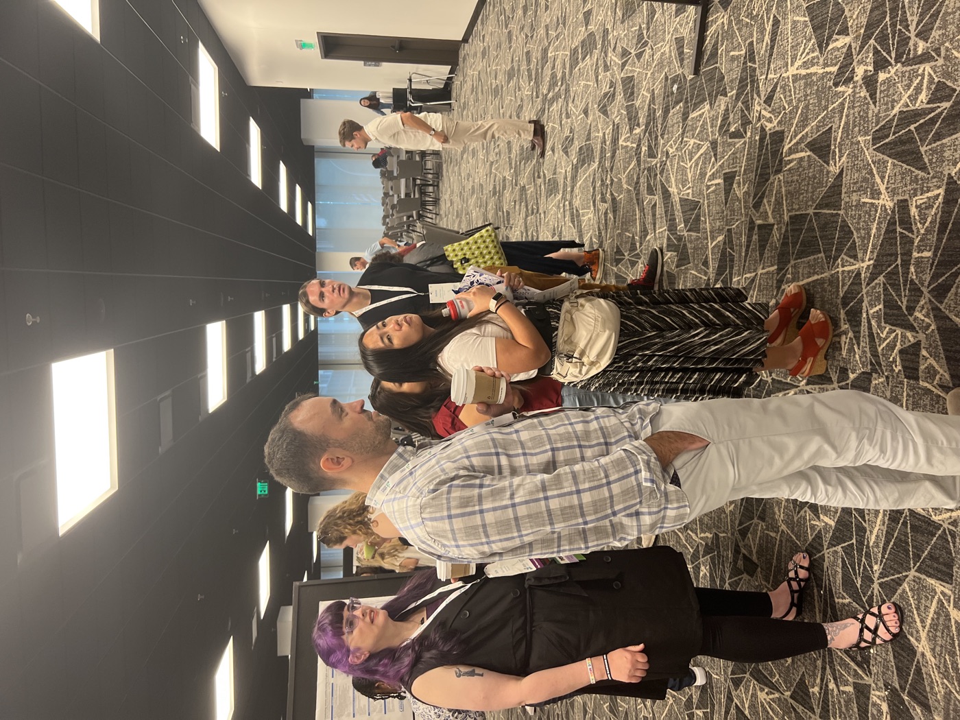 Attendees standing and talking in the conference poster hall